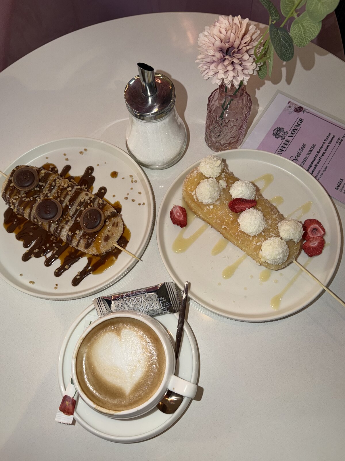 Latte mit Latte Art und Croissant auf Marmor